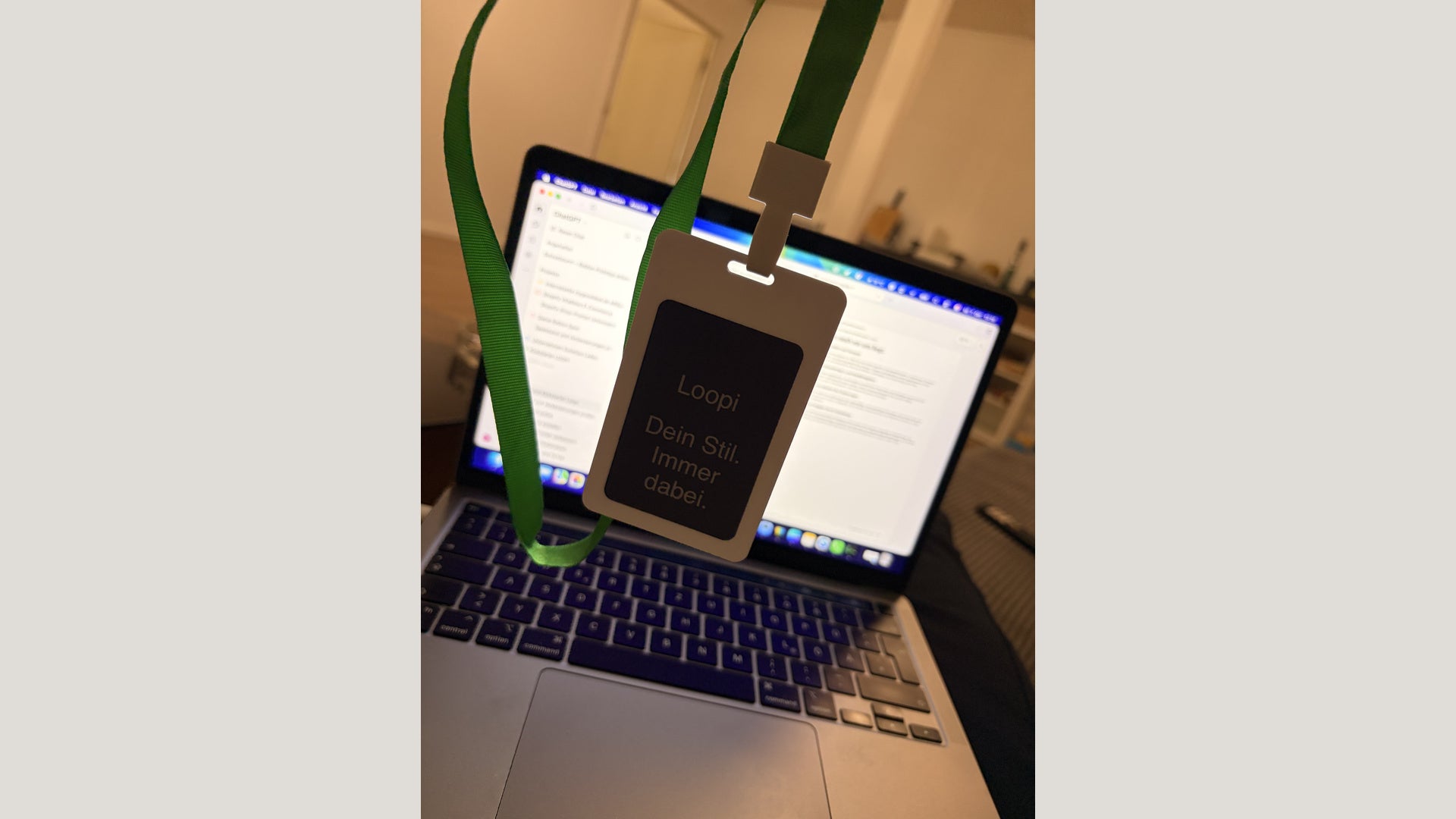 Original photograph of the white Loopi device prototype with a green carrying strap and Loopi slogan